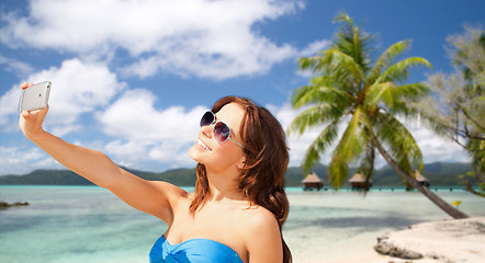 Image showing woman taking selfie by smartphone on beach