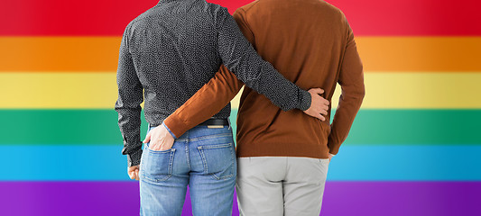 Image showing close up of hugging male gay couple over rainbow