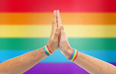 Image showing hands with gay pride wristbands make high five