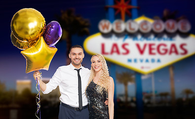 Image showing happy couple with party caps and balloons