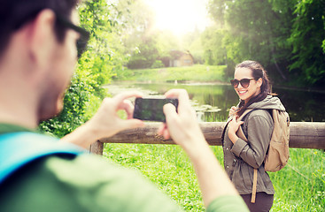 Image showing couple with backpacks taking picture by smartphone