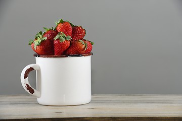 Image showing strawberry in a mug on a wooden table