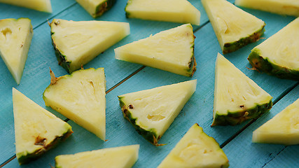 Image showing Pineapple pieces on blue desk 