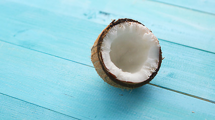 Image showing Half coconut on blue table 