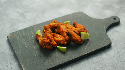 Image showing Chicken wings with lime slices