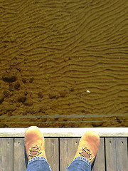 Image showing feet in suede shoes on a dock