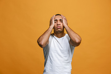 Image showing Man having headache. Isolated over orange background.