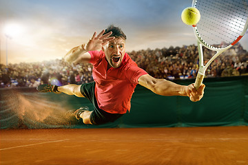 Image showing The one jumping player, caucasian fit man, playing tennis on the earthen court with spectators