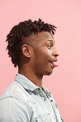 Image showing The crazy business Afro-American man standing and wrinkle face pink background. Profile view.