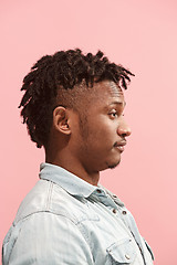 Image showing The surprised business Afro-American man standing and looking pink background. Profile view.