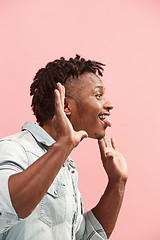 Image showing The crazy business Afro-American man standing and wrinkle face pink background. Profile view.