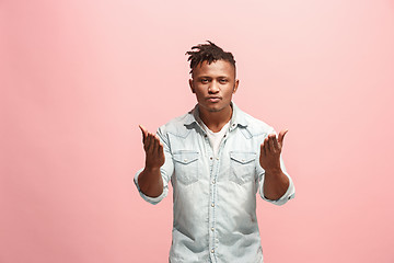 Image showing Beautiful male half-length portrait isolated on pink studio backgroud. The young emotional surprised man