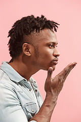 Image showing Portrait of attractive Afro-American man with air kiss isolated over pink background