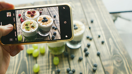 Image showing Crop hand taking photo of fresh desserts