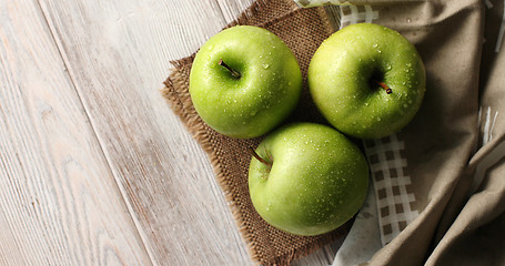 Image showing Wet green apples on canvas