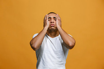 Image showing Man having headache. Isolated over orange background.