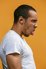 Image showing Crazy Afro-American man is looking funny against orange background