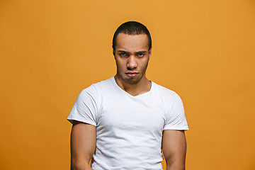 Image showing The serious businessman standing and looking at camera against studio background.