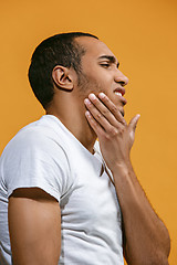 Image showing Sad Afro-American man is having toothache. against orange background