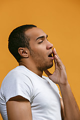 Image showing Bored Afro-American man want to sleep against orange background