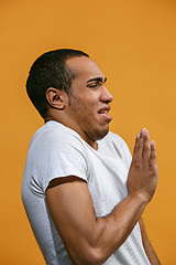 Image showing Disgust Afro-American man is looking disgustingly against orange background