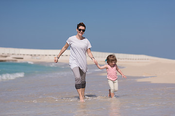 Image showing mother and daughter running on the beach