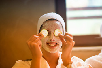 Image showing woman is getting facial clay mask at spa