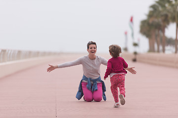 Image showing mother and cute little girl on the promenade by the sea