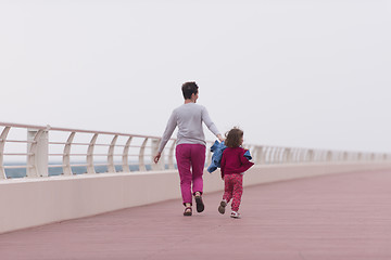 Image showing mother and cute little girl on the promenade by the sea