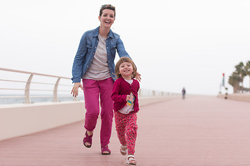 Image showing mother and cute little girl on the promenade by the sea