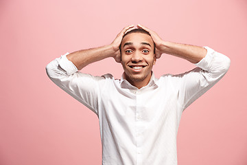 Image showing The young attractive man looking suprised isolated on pink