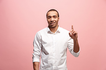 Image showing The happy business man point up, half length closeup portrait on pink background.