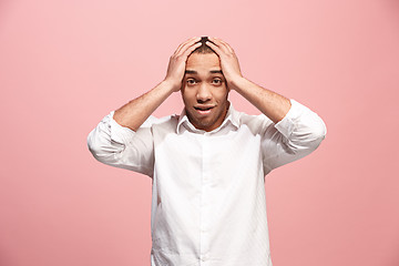 Image showing The young attractive man looking suprised isolated on pink