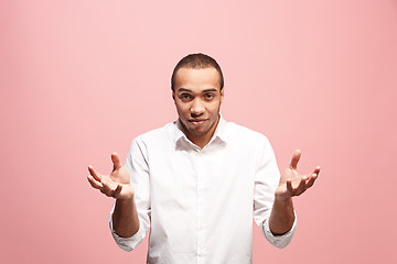 Image showing Beautiful male half-length portrait isolated on pink studio backgroud. The young emotional surprised man