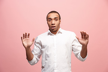 Image showing The young attractive man looking suprised isolated on pink