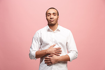 Image showing The happy business man standing and smiling against pink background.