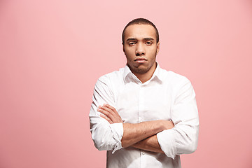 Image showing The serious businessman standing and looking at camera against pink background.