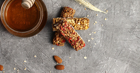 Image showing Oat bars and jar of honey