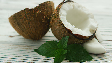 Image showing Halves of fresh coconut with mint leaves