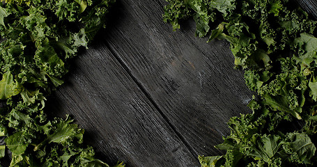 Image showing Composed green salad leaves on wood