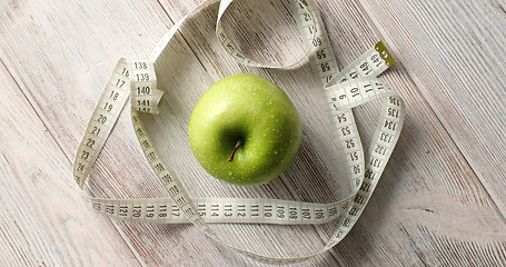 Image showing Green apple and measuring tape on table