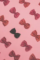 Image showing Pink and black pasta farfalle lies diagonally