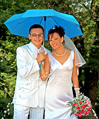 Image showing Bridegroom and bride with the umbrella