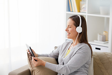 Image showing happy woman with tablet pc and headphones at home