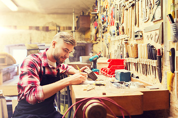 Image showing carpenter working with wood plank at workshop