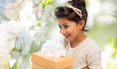 Image showing happy girl with gift box over cherry blossom