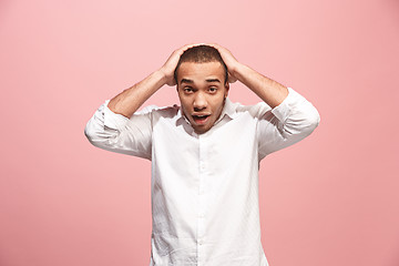 Image showing The young attractive man looking suprised isolated on pink