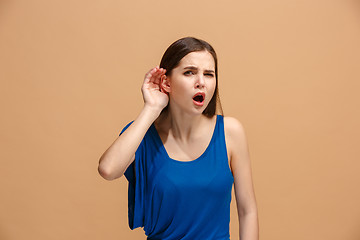 Image showing The young woman is listening something on the pastel background.