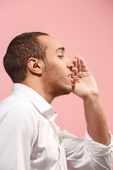 Image showing Isolated on pink young casual man shouting at studio