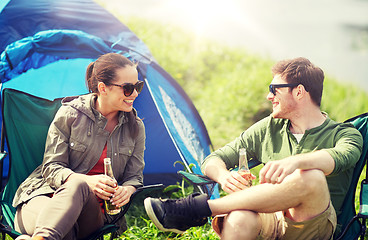 Image showing happy couple drinking beer at campsite tent